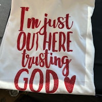 a shirt that says i'm just out there trusting god